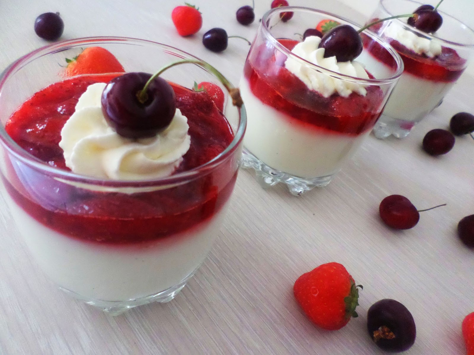 Vanilla Strawberry Pudding serving in cups as Panna Cotta Inspired topped with whipped cream and cherries