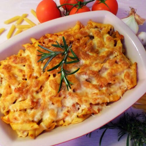 Baked tuna pasta served in a casserole, topped with melted golden mozzarella cheese
