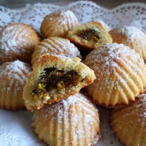These golden Best Pistachio Cookies (Maamoul with pistachio) is covered with powdered sugar served in a beautifully desserts dantail sheet