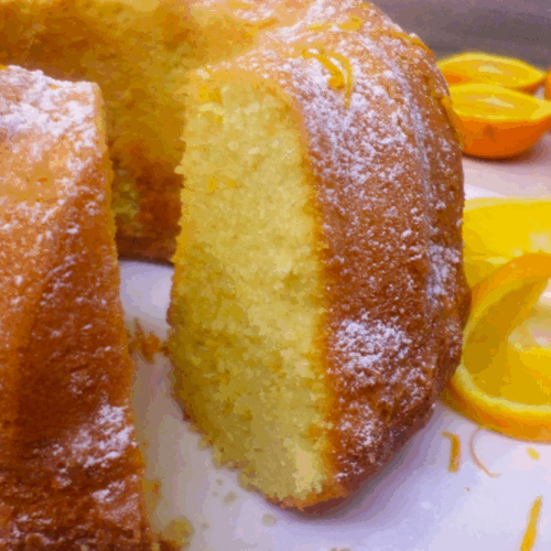 Moist and fluffy golden orange cake soft and covered with a white snowy powdered sugar