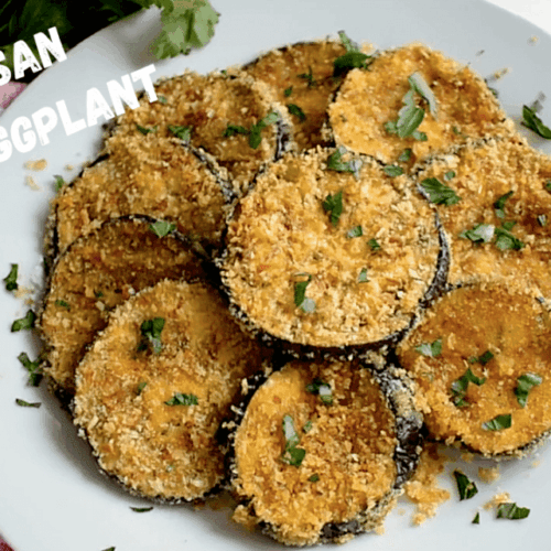 Crispy Parmesan Baked Eggplant slices served on a round white plate, topped with golden breadcrumbs and freshly chopped parsley for garnish, creating a warm and appetizing presentation