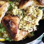 Authentic Middle Eastern Rice and Chicken Kabsa served in a traditional pot, garnished with fresh parsley and lemon slices.