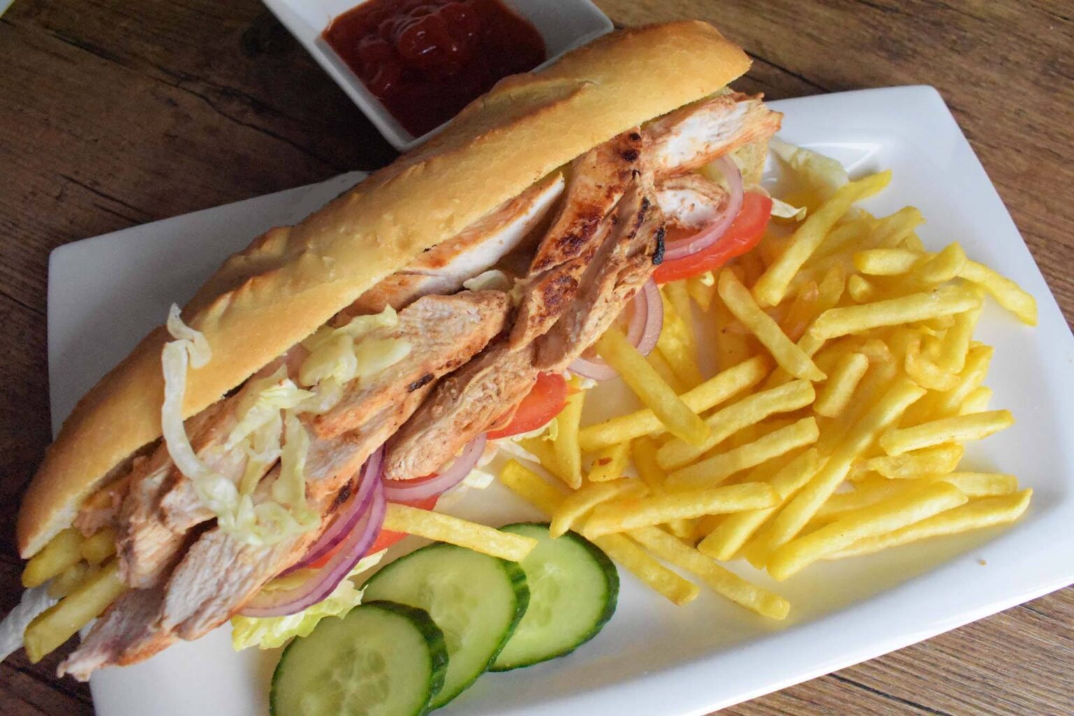 Chicken Shawarma Sandwich served on a clean white plate with a generous side of crispy golden French fries.