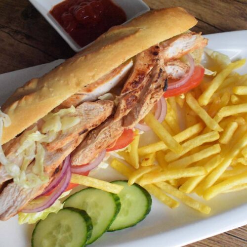 Chicken Shawarma Sandwich served on a clean white plate with a generous side of crispy golden French fries.